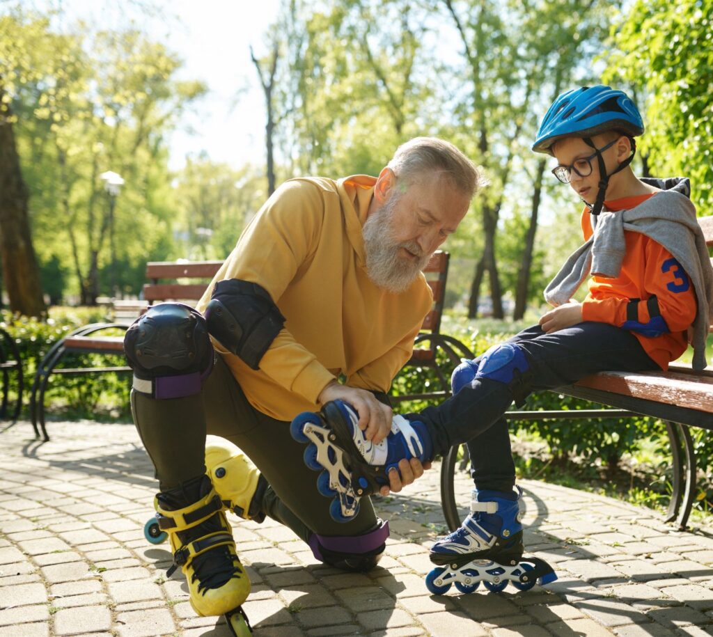 A father helping his son put on roller blades before heading out on the Swamp Rabbit Trail in Greenville, South Carolina